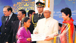 Governor Jagannath Pahadia and Union Social Justice and Empowerment Minister Kumari Selja hand over a certificate to a differently abled girl at a function in Ambala on Monday. 