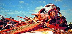 A vehicle sits on a pile of debris from the destruction caused by a tornado that touched down in Washington, Illinois, on Sunday