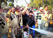 People help douse the flames after fire broke out at Jhuggi Basti in Rampura on Tuesday