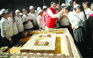 Schoolchildren stand near a toilet-shaped 250-kg cake during a function to mark World Toilet Day, organized by the Sulabh International, a non-government organization, in New Delhi on Tuesday