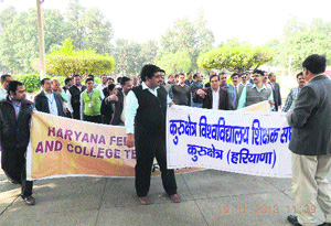 Kurukshetra varsity teachers march in procession to the vice-chancellors office on the KU campus on Tuesday. 