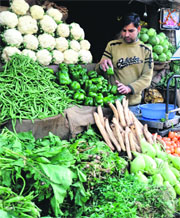 Shopkeepers wait for customers as the rise in the prices of vegetables has burnt a hole in the pocket of the common man in Jammu. 