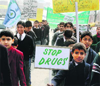 School students hold placards during a rally to create awareness against drugs in Srinagar on Tuesday
