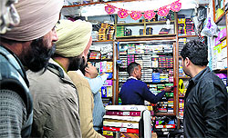 An MC staff puts a mark on the encroached portion of a shop in Gur Mandi in Ludhiana on Tuesday