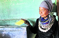 A Bru tribal woman casts her vote through postal ballot in Naisingpara Bru refugee relief camp in Tripura on Tuesday
