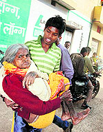 An elderly voter is carried to a polling station by a relative to cast her vote in Raipur on Tuesday