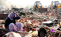 A woman wails after losing her house to the demolition drive at Colony No 5, Sector 51