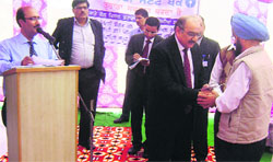 PK Malhotra, deputy managing director, SBI, presents an approval letter to a beneficiary at Daudpur near Bija on Wednesday. A tribune Photograph