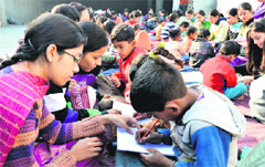 Students of the GMT College of Education teach children of Peeru Banda Colony, Salem Tabri, in Ludhiana on Wednesday. Photo: Inderjeet Verma