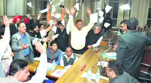 Councillors of the SAD-BJP throw the torn copies of the special agenda during a meeting on Thursday. Tribune photo