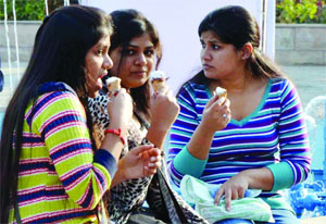 Girls enjoy ice-cream in the winter during the India International Trade Fair at Pragati Maiden in New Delhi on Wednesday. 