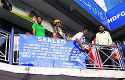 Officials of the Srinagar Municipal Corporation seal a commercial building in Srinagar on Thursday