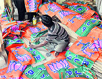 A BJP worker prepares party flags in Jammu
