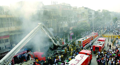Firefighters try to douse fire wich broke out in cloth shops at Naya Katra, Chandni Chowk, in New Delhi on Friday.