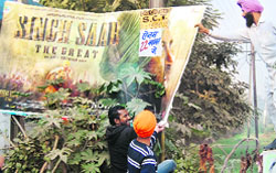Youths tear a poster of Sunny Deol-starrer Singh Saab The Great in Amritsar on Friday. Photo: Sameer Sehgal