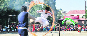 A student jumps through a fire ring while performing martial arts during the annual Sports Day function at Doon International School in Dehradun on Saturday.