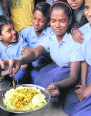 Schoolchildren show a dead mouse that was found in the mid-day meal at a school in Patna on Saturday.