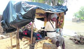 A villager stays put in a makeshift shelter.