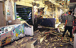 People inspect the explosion site in Karachi on Saturday