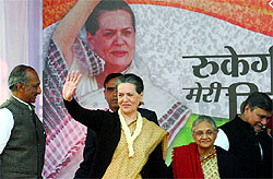 Congress president Sonia Gandhi waves to the supporters as Delhi Chief Minister Sheila Dikshit and DPCC president J.P. Aggarwal (L) look on during an election rally in East Delhi on Sunday