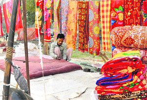 As winter sets in a roadside worker is busy stitching quilts in Karnal. 