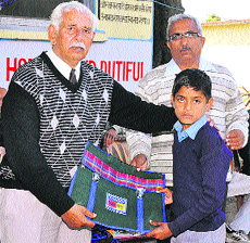 Gayatri Seva Samiti office-bearers distribute study material to school students in Nurpur on Saturday. 
