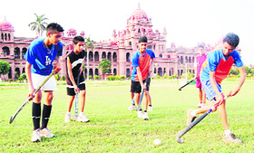 Hockey players practise their game while Khalsa College can be seen in the background in Amritsar.