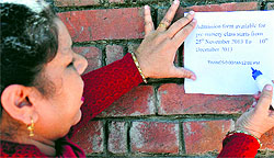 A teacher of the nursery wing of Government Model Senior Secondry School, Sector 16, Chandigarh, pastes a notice announcing dates pertaining to issue and receipt of admission forms for pre-nursery at the entrance of the school on Monday