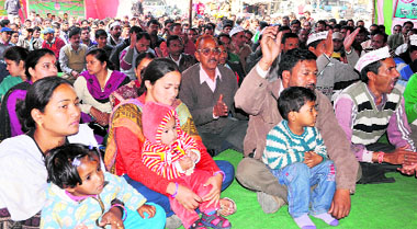 Striking contractual power employees, along with their families, stage a protest near Parade Ground in Dehradun on Monday.