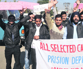Candidates for the posts of jail warden protest in support of their demands in Jammu on Monday. 