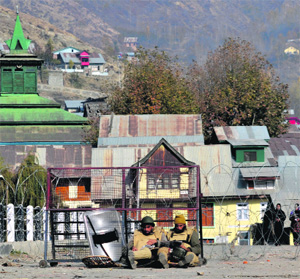 The police block the Baramulla-Kupwara road with barbed wire following a stone-throwing incident in Baramulla on Monday. 