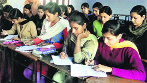 Students take part in a writing competition at SDP College in Ludhiana on Monday. 