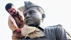 A worker cleans a statue of 26/11 terror attack martyr Tukaram Omble in Mumbai on Monday. 