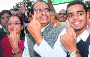 Madhya Pradesh Chief Minister Shivraj Singh Chauhan with his wife Sadhna Singh (L) and son Kartikey Singh Chouhan (R) after casting votes at Jait village in Sehore on Monday. 