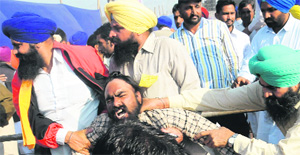SAD supporters thrash a member of the Unemployed Linemen Union that tried to disrupt the CMs speech at the Talwandi Sabo Thermal Power Plants inauguration in Banawala on Monday. 