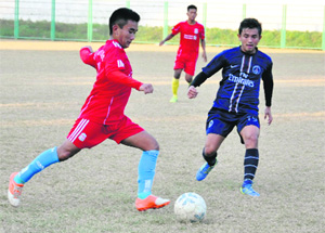 Players struggle to grab the ball in a match in the Dehradun District Super League Football Tournament in Dehradun on Tuesday. 
