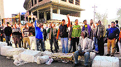 Shopkeepers block the state highway near the old bus stand in Kangra on Tuesday
