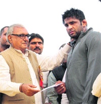 Chief Minister Bhupinder Singh awards a cheque to Sumit Kumar for winning the Bharat Kesri bout in Rohtak on Tuesday.