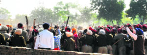 Punjab police personnel try to control the two groups involved in a clash in Moga on Tuesday