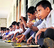 Children partake of mid-day meal in a school