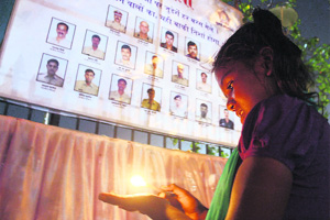 A girl lights a candle to pay homage to 26/11 terror attack martyrs outside Taj Mahal Hotel in Mumbai on Tuesday. 