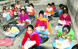 Students brave the cold as they sit on the floor of Government Elementary School in Bathinda