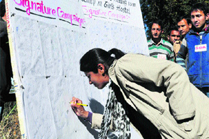 A girl signs during a signature campaign at HPU in Shimla on Wednesday. 