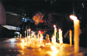 A girl lights a candle to pay homage to 26/11 martyrs outside Mumbais Taj hotel