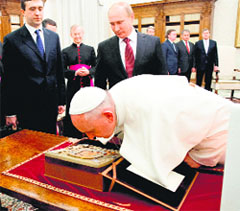 Pope Francis bends to kiss an icon of the Madonna given to him by Russian President Vladimir Putin during their private audience at the Vatican on Monday.