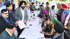 DPS Kharbanda, MC Commissioner, receives a property tax cheque by Ranjit Avenue shopkeepers during a camp in Amritsar on Thursday.