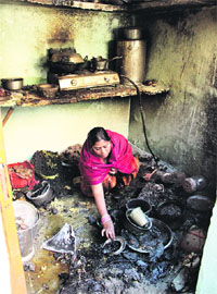 A woman collects utensils from the kitchen where the blast occurred