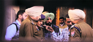 Police officials question a watchman at Dr Hira Singh Road near Ghumar Mandi in Ludhiana on Friday