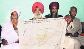 Residents of Manawala village show maps near Amritsar on Sunday