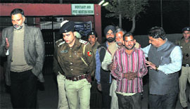 The victims father and police officials, including SSP Naunihal Singh (left), come out of the mortuary at the GMSH, Sector 16, in Chandigarh on Sunday.